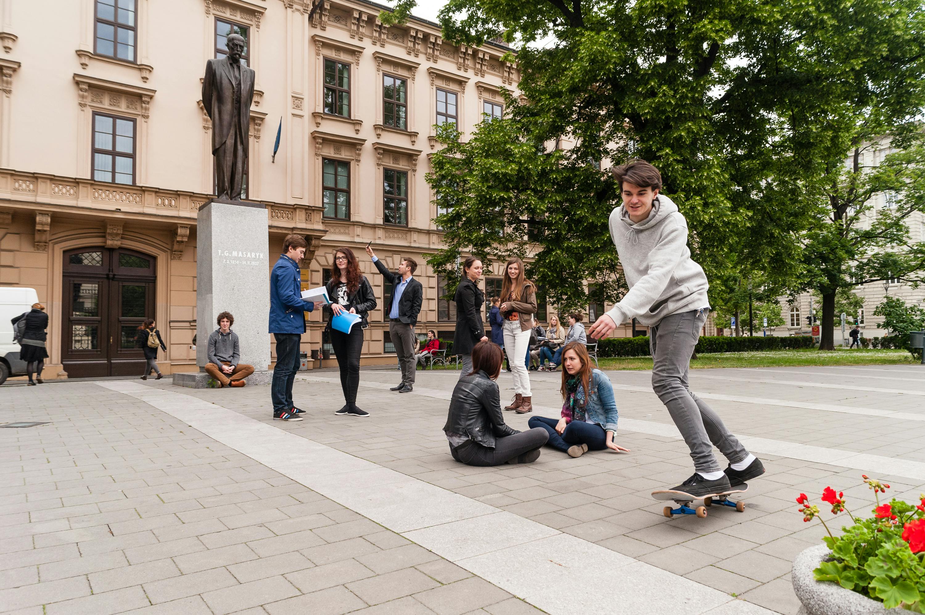 Studentinnen und Studenten vor dem Stammgebäude der Masaryk Universitaet in Brünn