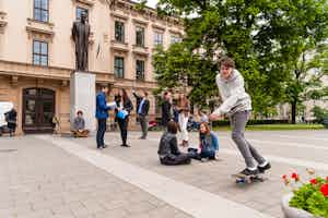 Studentinnen und Studenten vor dem Stammgebäude der Masaryk Universitaet in Brünn